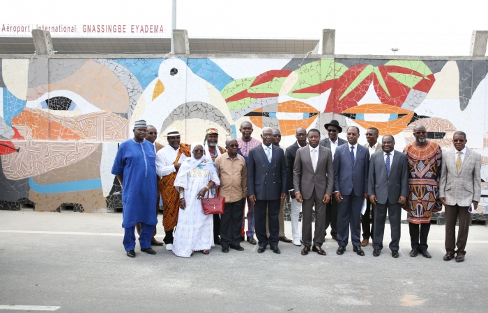 Photo de famille devant la fresque du mur de l'aéroport 